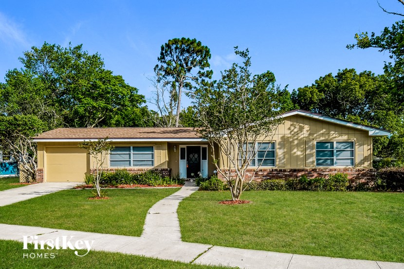 A house with a blue door and a small tree in front of it.