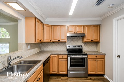 A kitchen with wooden cabinets and a stainless steel oven.