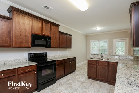 a kitchen with wooden cabinets and a black stove and a sink