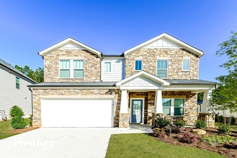 A two-story house with a stone facade and a white garage door.