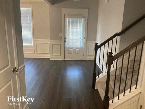 a living room with a staircase and wood floors