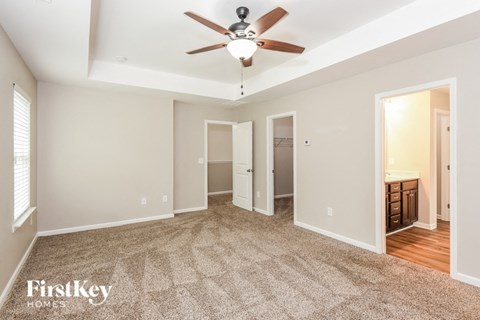 a living room with carpet and a ceiling fan