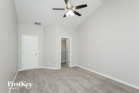 a bedroom with carpet and a ceiling fan