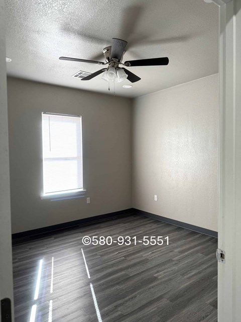 A room with a ceiling fan and a window.