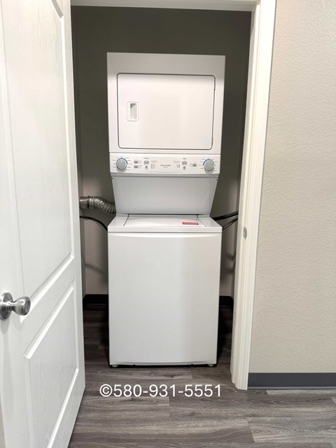 A white toilet with a bidet attachment is in a small room.