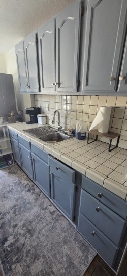 A kitchen with blue cabinets and a white tiled backsplash.