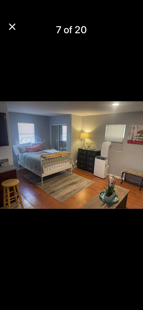 A bedroom with a bed, nightstand, and a chair.