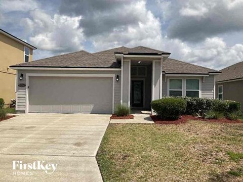 A house with a grey garage door and a brown roof.