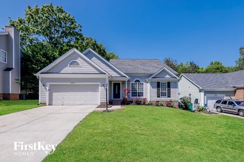 a white and blue house with a lawn and a garage