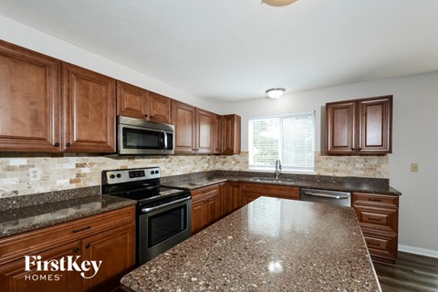 A kitchen with wooden cabinets and granite countertops.