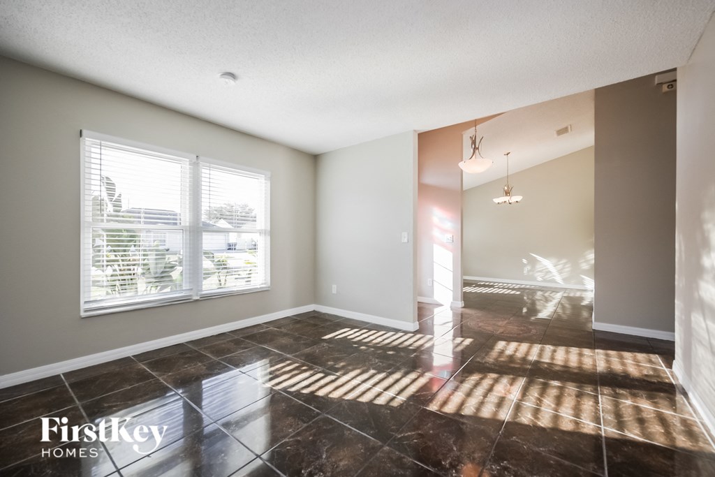 the living room and dining room of an empty house
