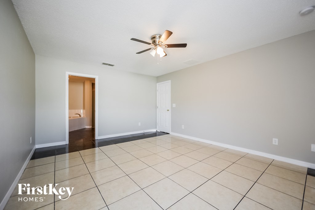 a clean and empty living room with a ceiling fan