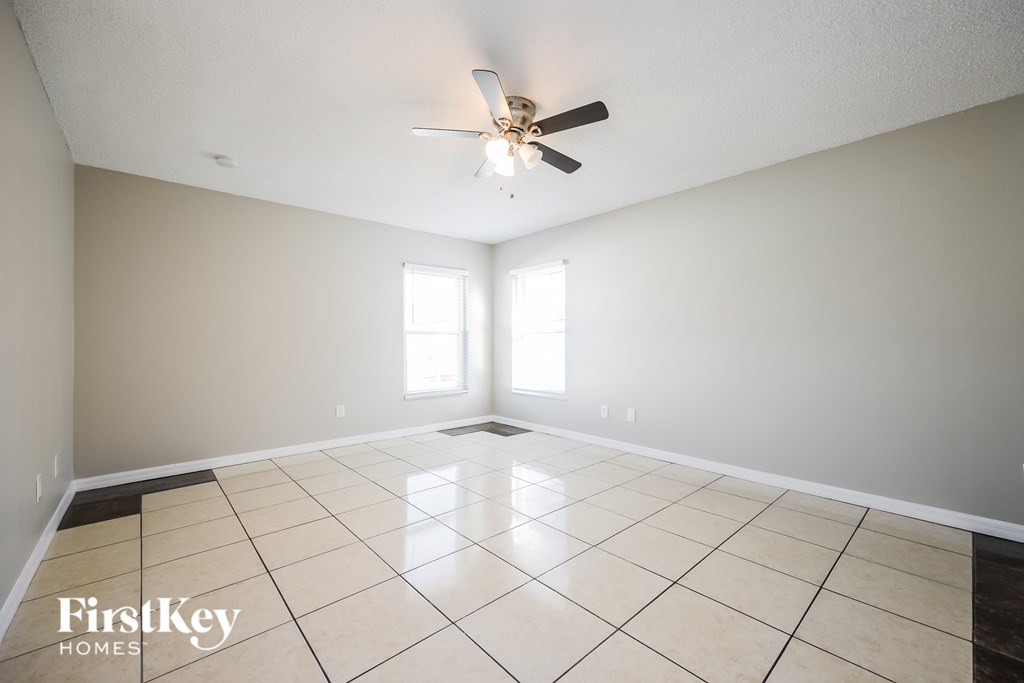 a clean and empty living room with a ceiling fan