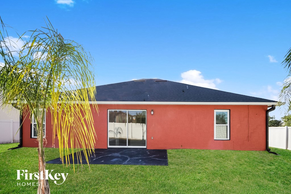 the front of a red house with a tree in the yard