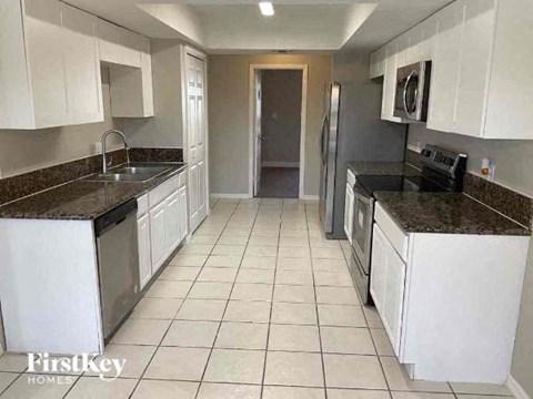 a kitchen with white cabinets and counter tops
