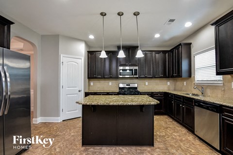 A kitchen with black cabinets and granite countertops.