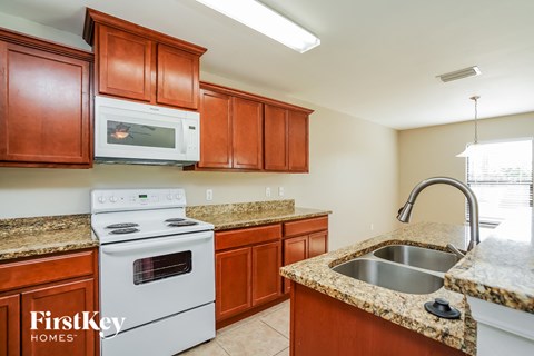 A kitchen with brown cabinets and a white stove top oven.