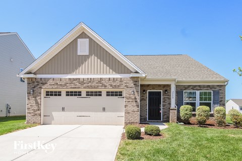 A two-story house with a garage and a driveway.