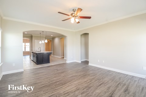 A spacious room with a ceiling fan and wooden flooring.