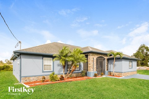 a blue house with palm trees in front of it