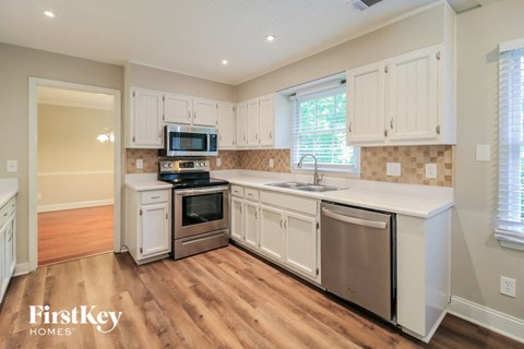 a kitchen with white cabinets and stainless steel appliances