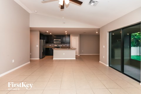 A spacious kitchen with a black refrigerator and a white island.