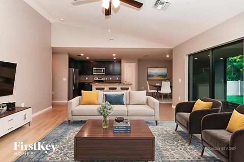 A living room with a white couch and a brown coffee table.
