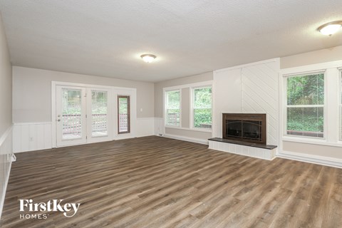 A spacious living room with a fireplace and wooden flooring.