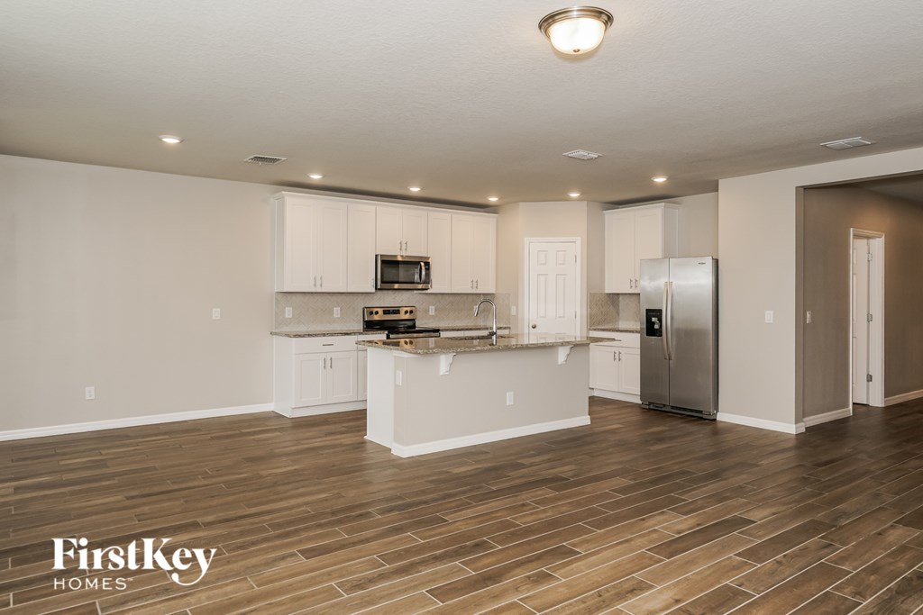 A kitchen with wooden floors and white walls.
