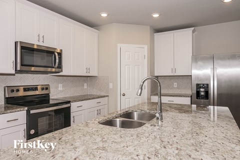 A kitchen with granite countertops and stainless steel appliances.