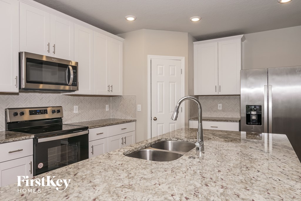 A kitchen with granite countertops and stainless steel appliances.
