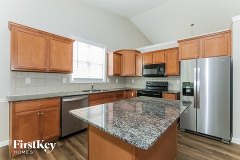 A kitchen with wooden cabinets and granite countertops.