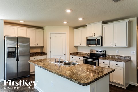 a kitchen with white cabinets and granite counter tops