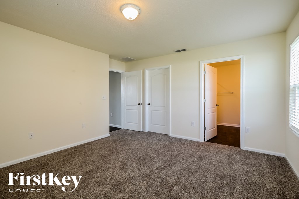 a master bedroom with carpeted flooring and white walls