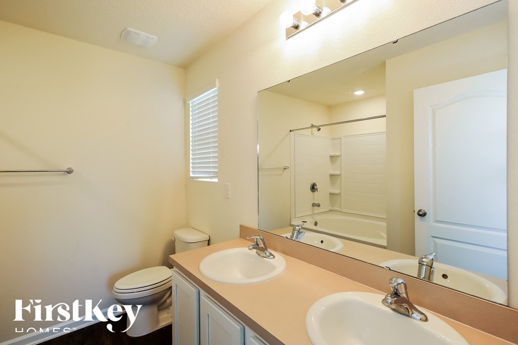a bathroom with two sinks and a shower and a toilet