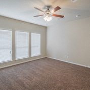 an empty living room with a ceiling fan