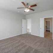 an empty living room with a ceiling fan