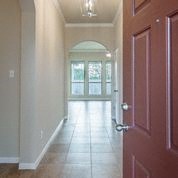 a hallway with a red door and a white floor