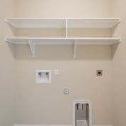 a white shelf on top of a bathroom wall