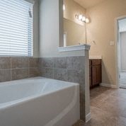 a bathroom with a large tub and a sink