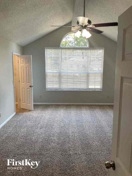 A room with a ceiling fan and a door.