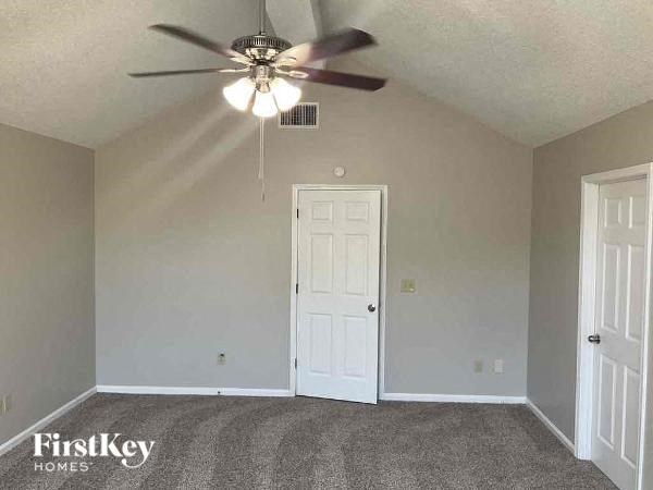 A room with a ceiling fan and two doors.