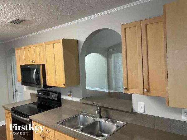 A kitchen with wooden cabinets and a stainless steel sink.