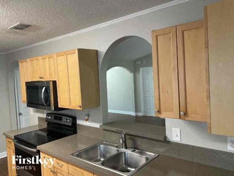 A kitchen with wooden cabinets and a stainless steel sink.