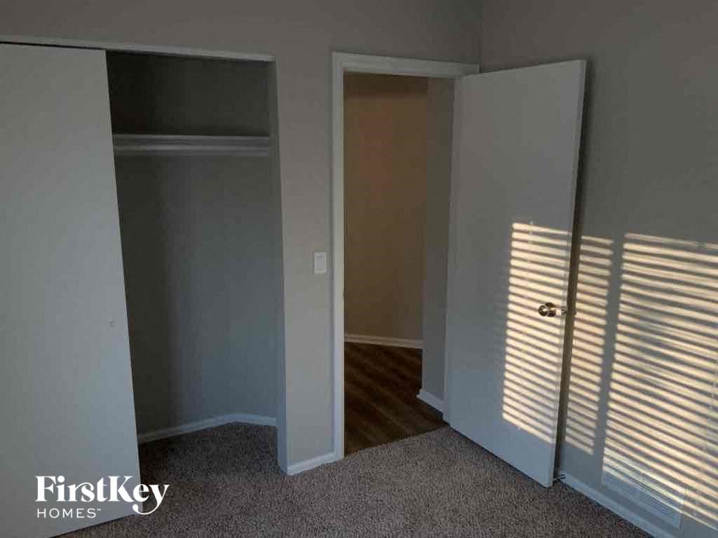 an empty room with a closet and a door to a window