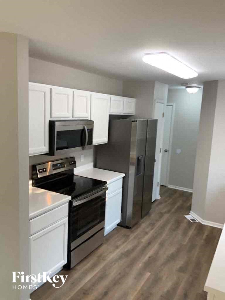 a kitchen with white cabinets and a stainless steel refrigerator