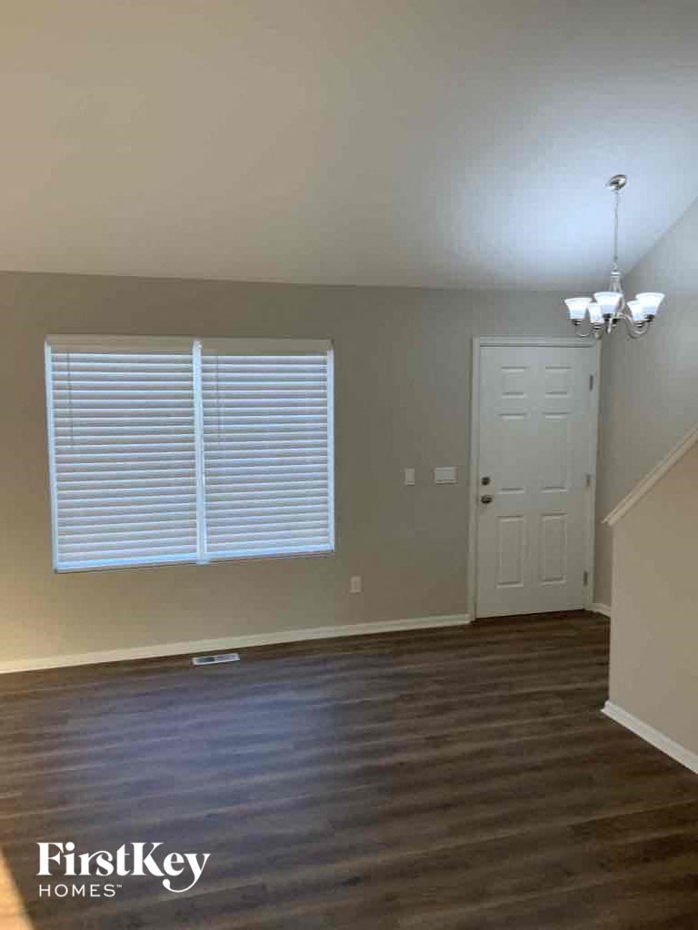 an empty living room with wood floors and a white door