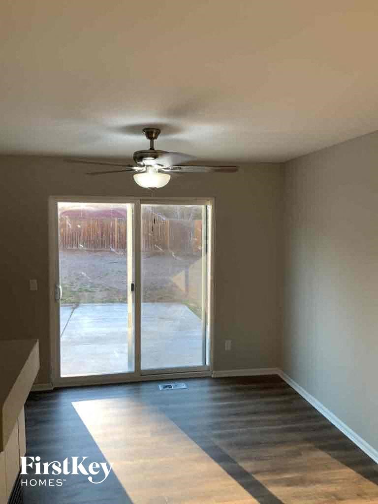 a empty living room with a ceiling fan and a window