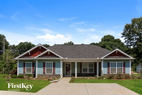 a blue house with a gray roof and red doors