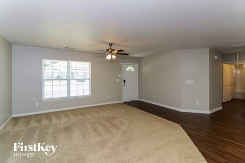 the living room of an empty house with a ceiling fan